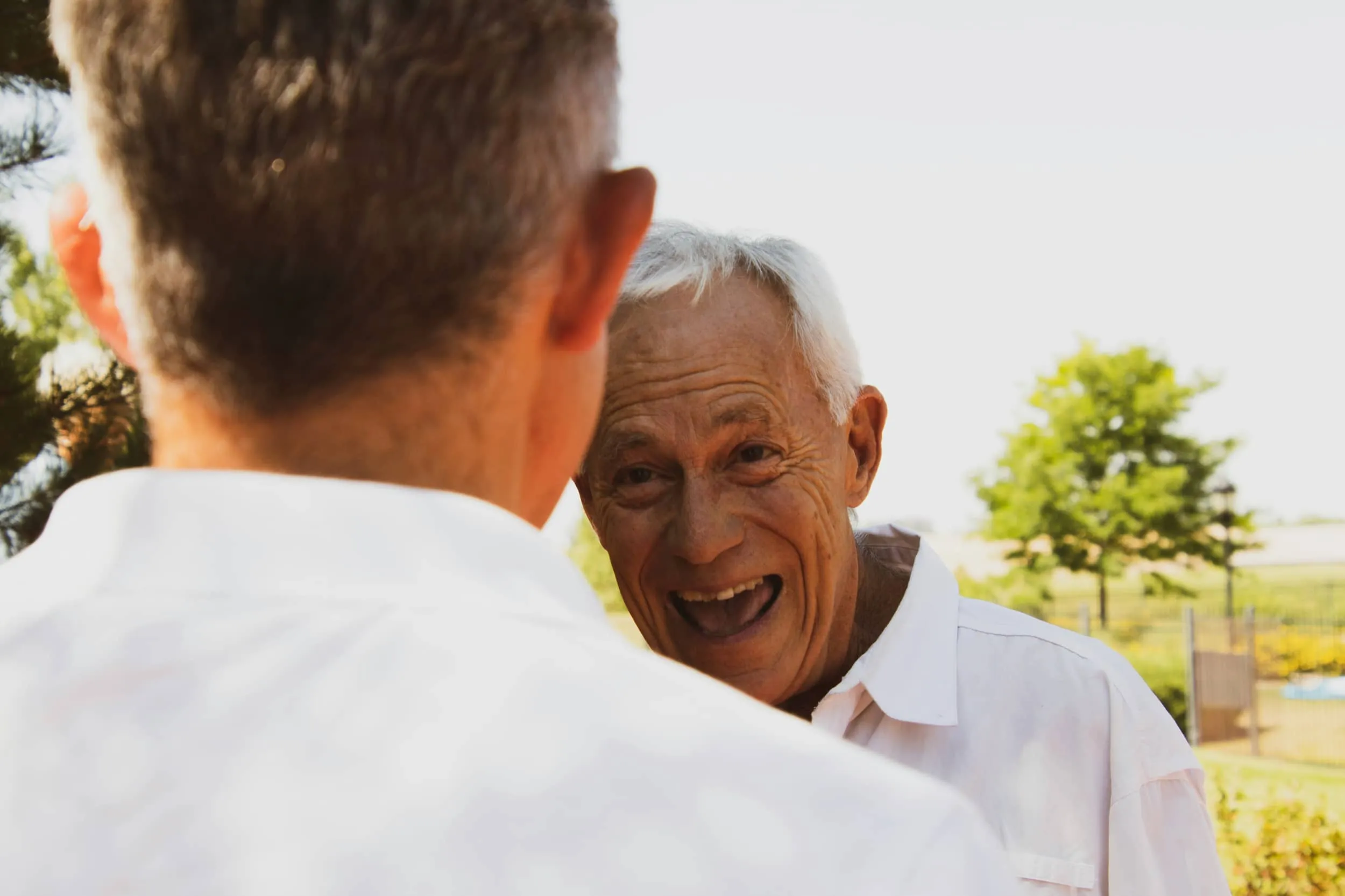 A father and son sharing a laugh outdoors